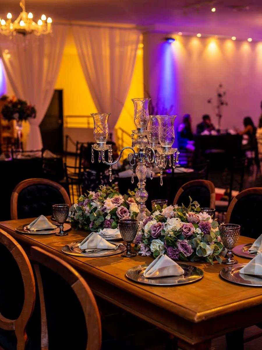 Mesa posta do Buffet Masterday com taças e arranjo de flores