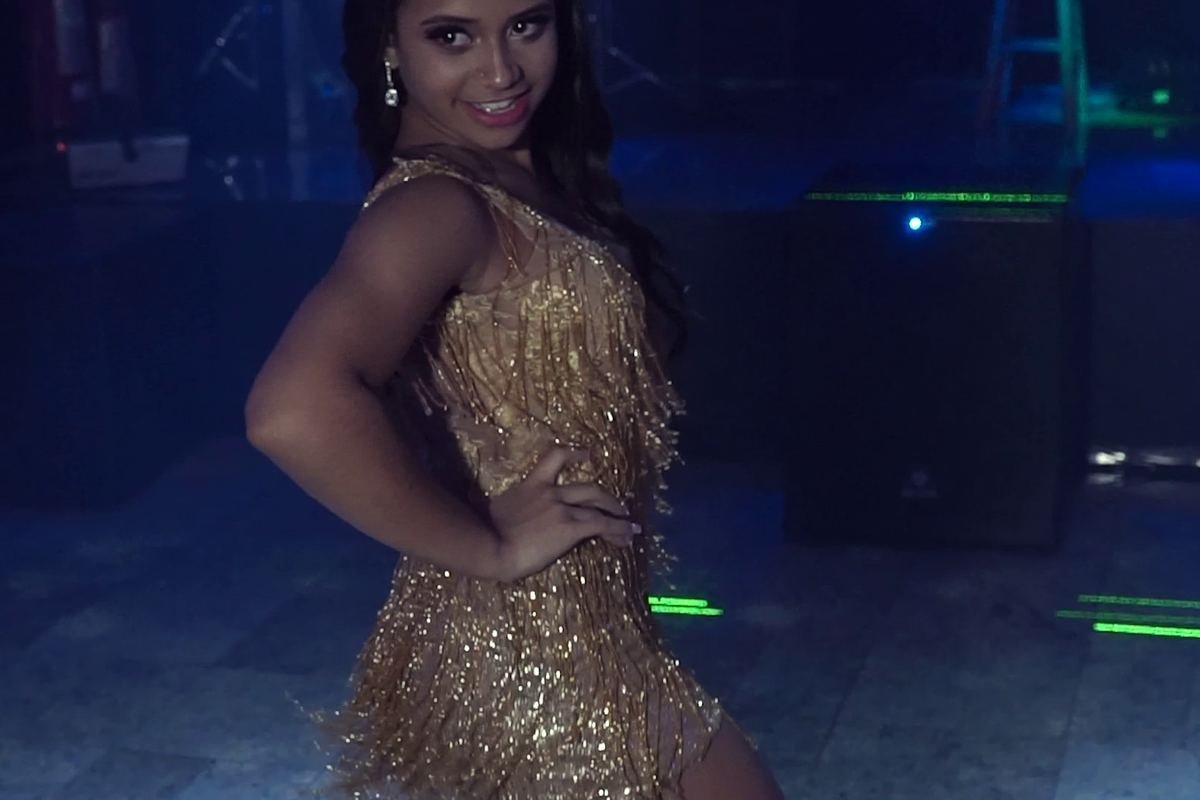 Debutante dançando na pista com lasers e luzes cênicas