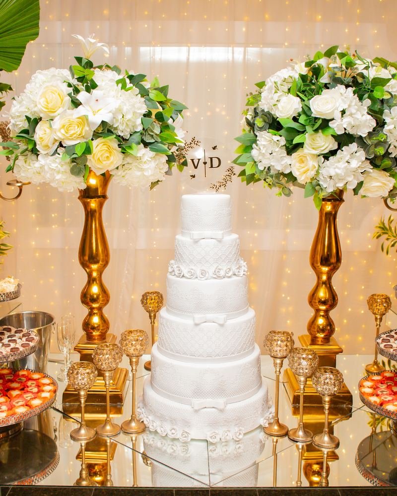 Mesa do bolo do casamento com arranjos de flores