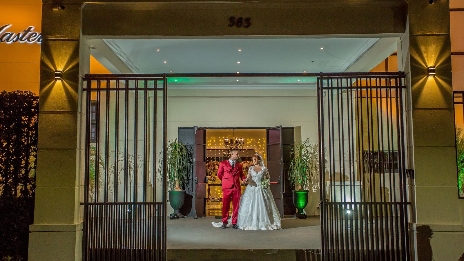 Fachada iluminada do Buffet Masterday em São Caetano do Sul com noivos na entrada