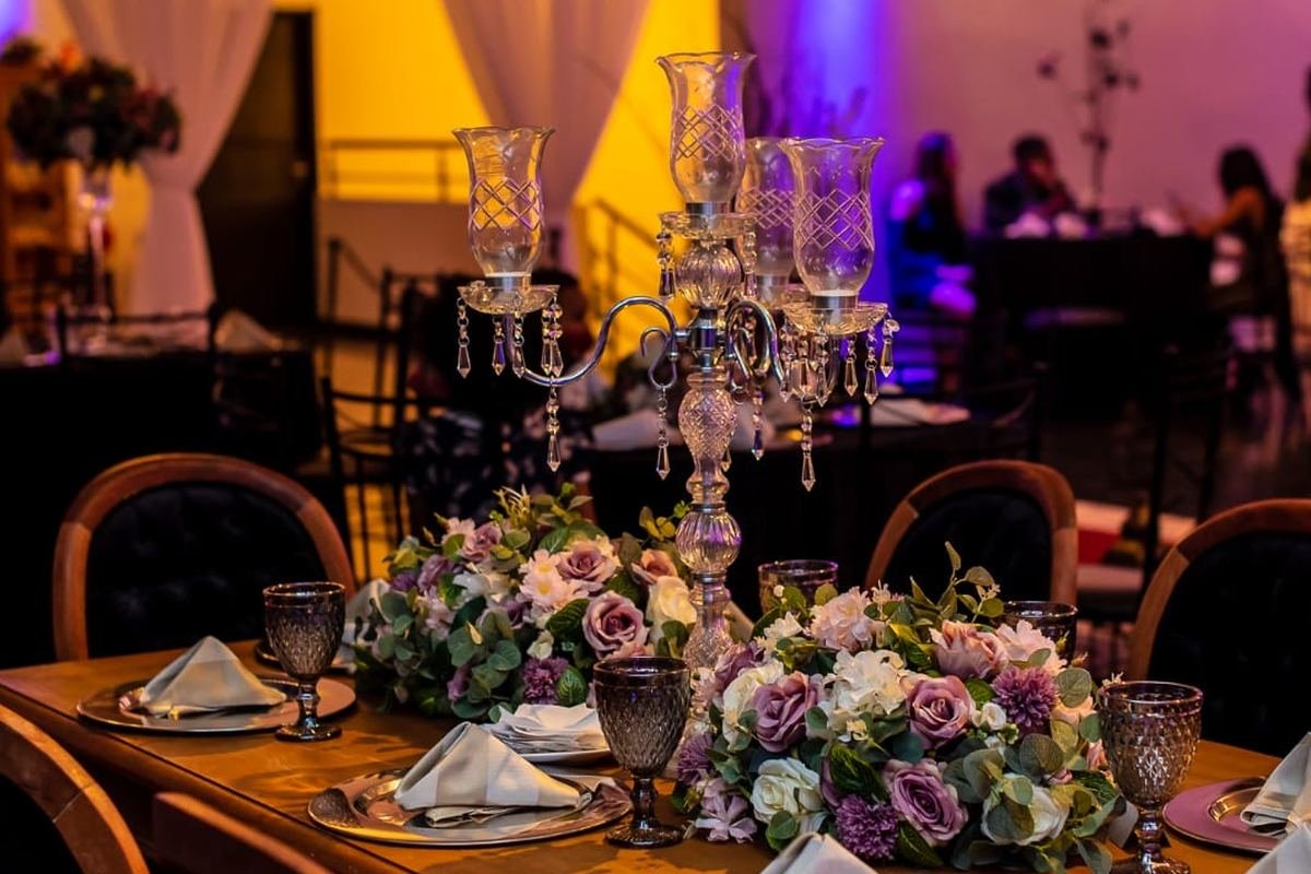 Mesa posta do Buffet Masterday, com taças e arranjo de flores