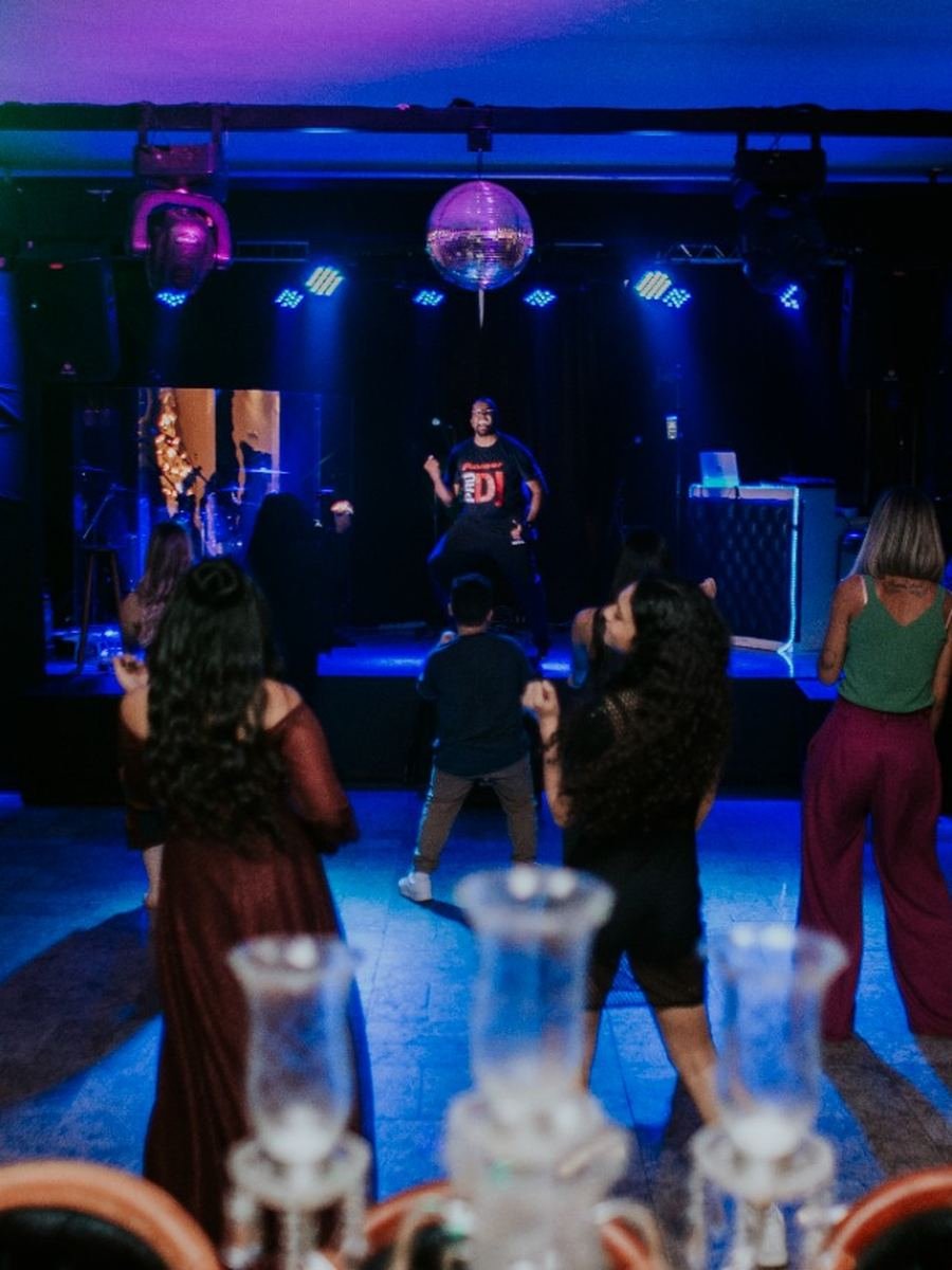 Pista de dança com DJ e luzes cênicas em festa de casamento